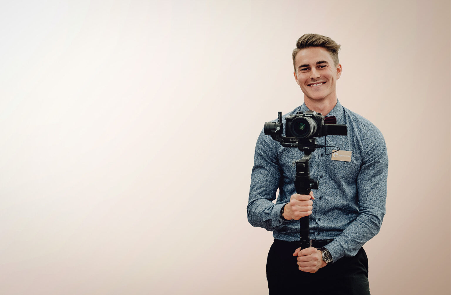 Sebastian Sieberer hält Video Kamera und lächelt